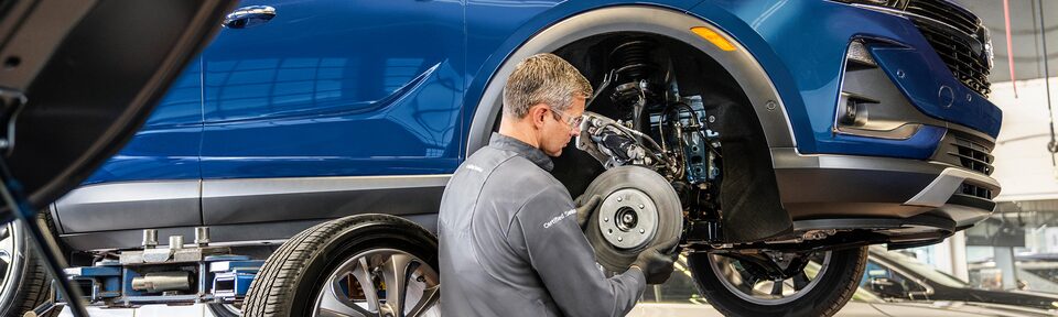 Certified Service Technician installing a brake rotor