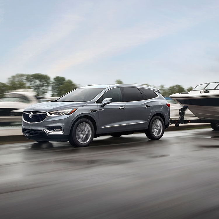 Buick Enclave SUV pulls boat along road