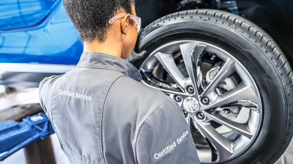 Buick Technician Mounting a New Tire on a Vehicle with Buick Logo and Text Overlay "Spring Tires and More Event"