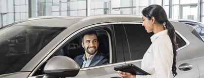 Buick Certified Service Technician Talking to a Buick Customer Sitting in His Vehicle