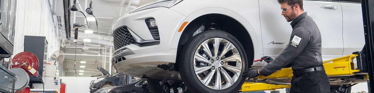 A Buick Certified Service Technician Installing an ACDelco Gold Battery in a GM Vehicle With Text Overlay "Winter Service Event" and "Prepare your Buick for the new season with our Winter Service Event, featuring offers on batteries, cabin and engine air filters, wiper blades, and more."