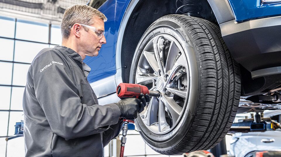 Buick Certified Service technician performing a tire rotation