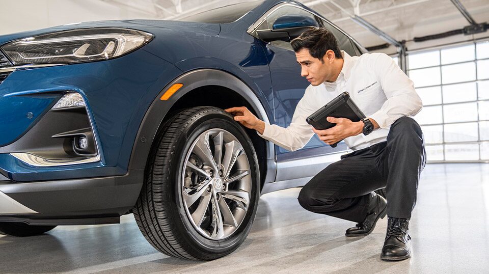 Buick Certified Service technician inspecting the underside of a vehicle