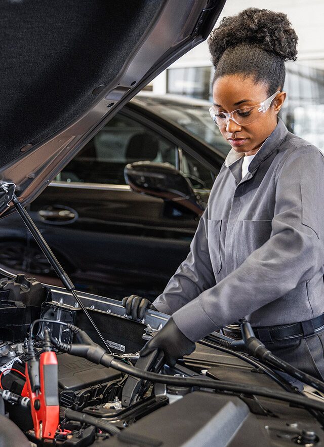Buick Certified Service Technician Works Under the Hood of Vehicle