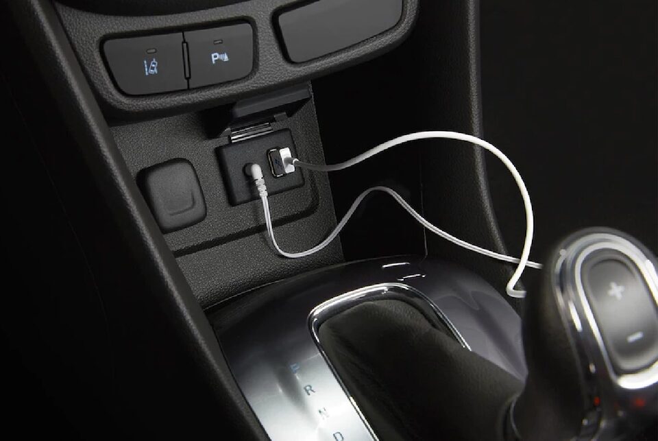 Image of someone using their iPhone to connect to the Apple CarPlay pairing features in a Buick vehicle.