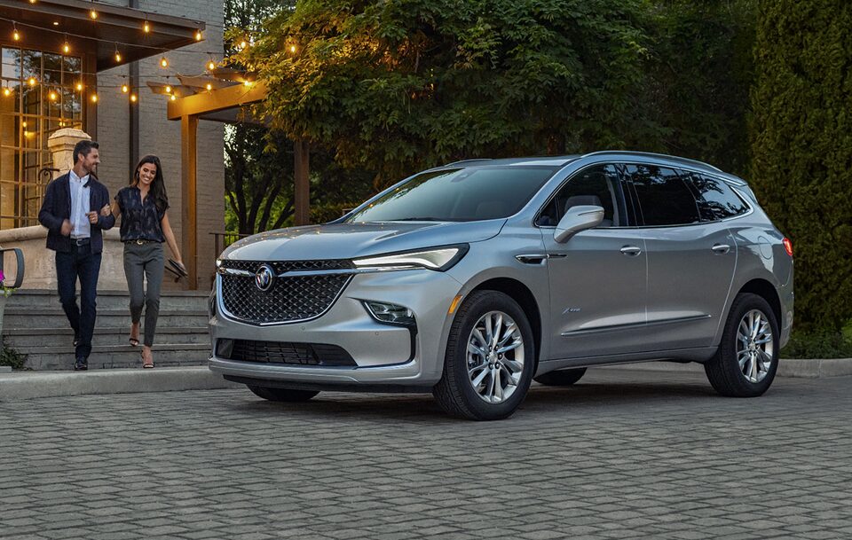 A Couple Leaving a Building Walking Towards their Stylish Buick Enclave Avenir