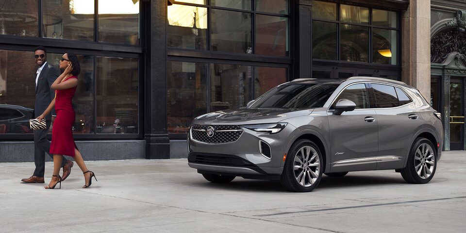 A Couple Leaving a Building Walking Towards their Stylish Buick Enclave Avenir