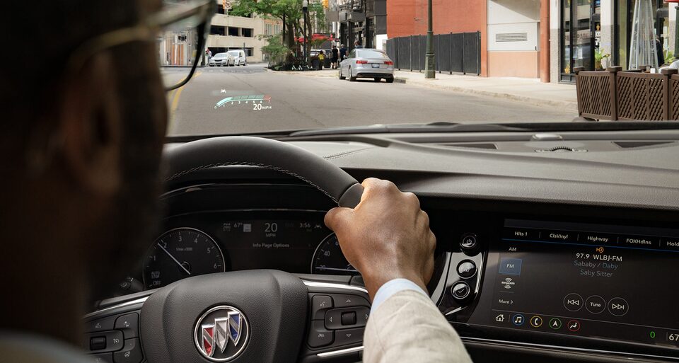 A Buick Encore SUV Owner Uses the Heads-Display While Driving Through the City