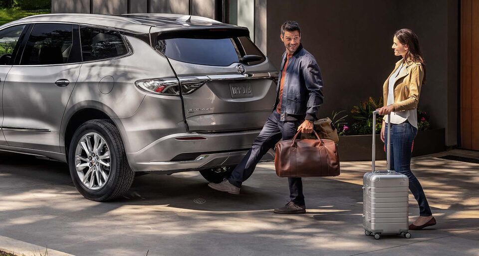 A Man Uses the Hands-Free Liftgate On His Buick Enclave As He Prepares to Loads Luggage In The SUV