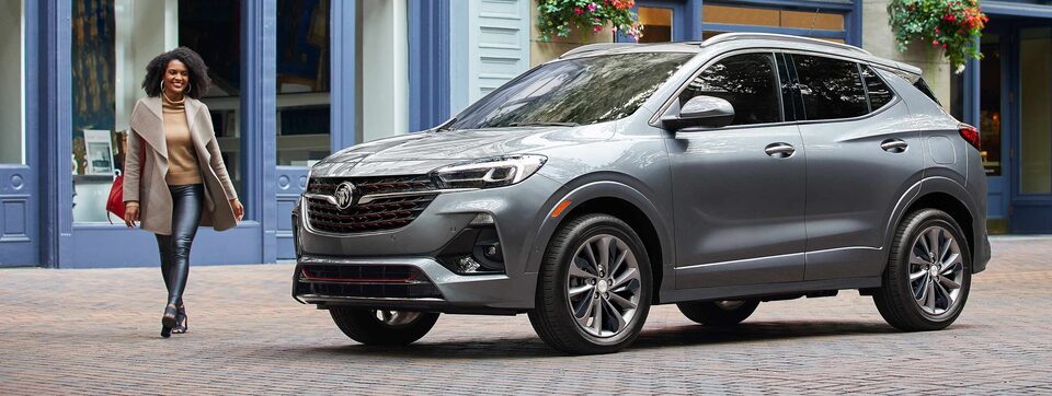 A Woman Approaches Her Parked Buick Envision