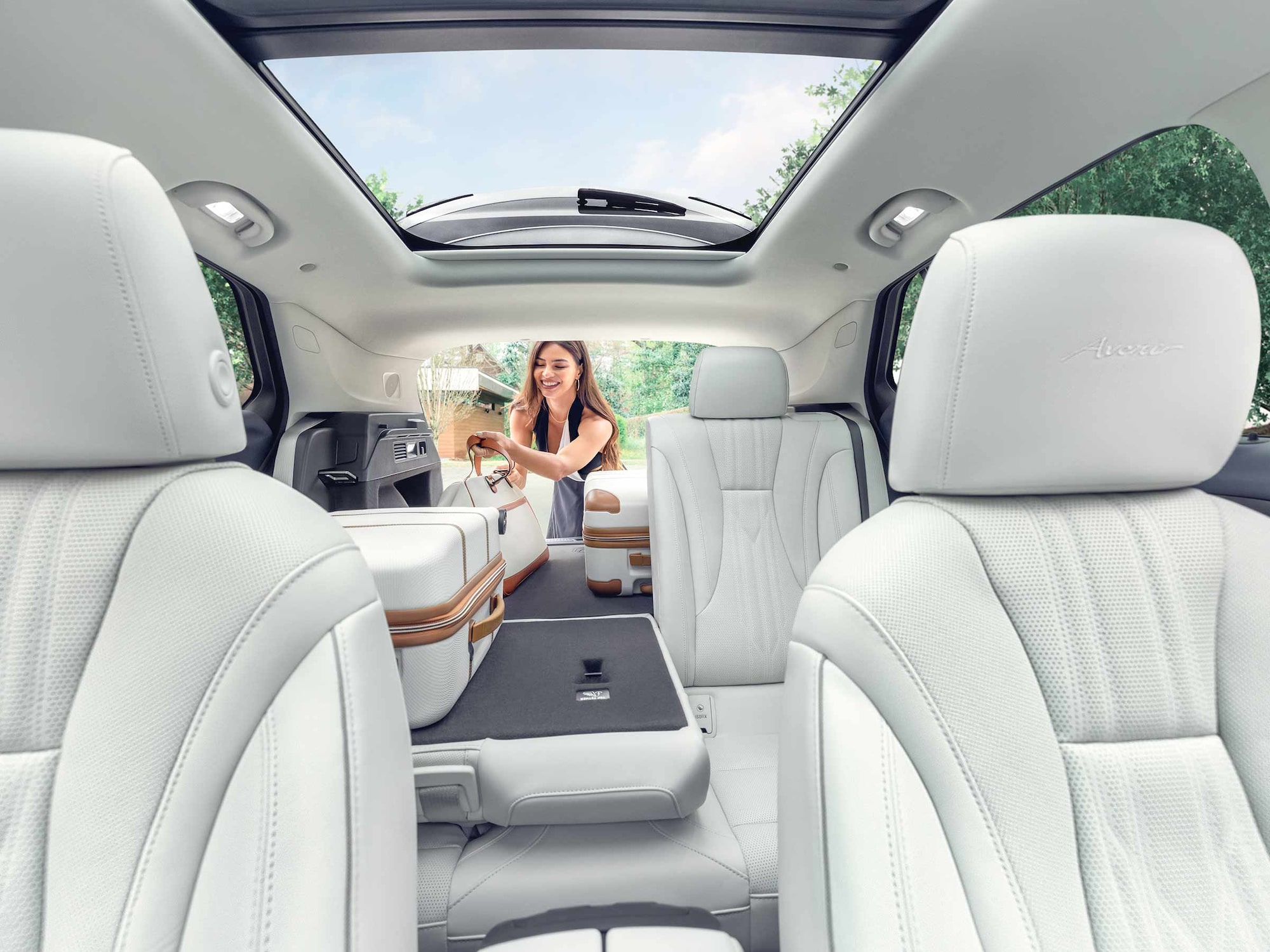 Interior View of a 2025 Buick Envision 5 Passenger SUV with a Person Loading Luggage Into the Trunk
