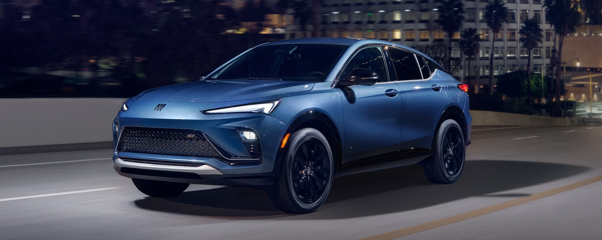 Three-quarters View of the 2026 Buick Envista Driving Out of the City Under a Street Light