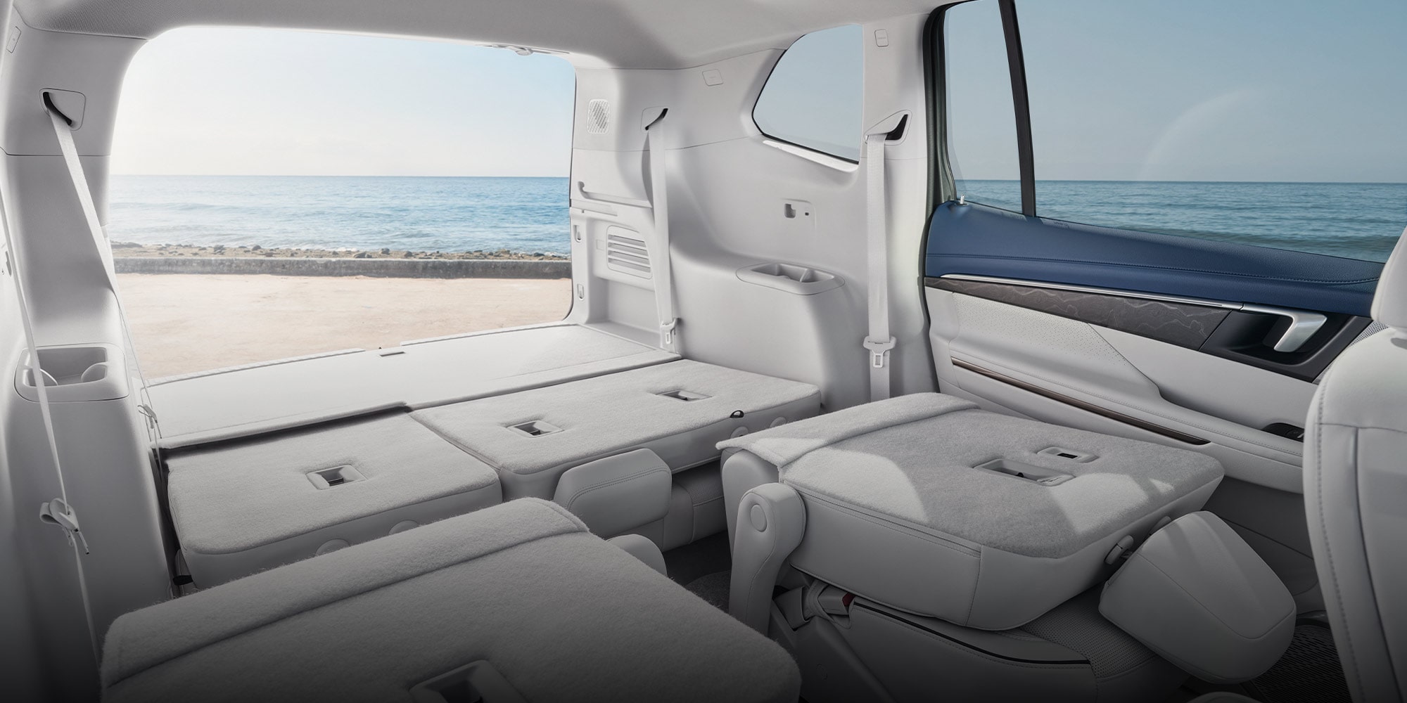 The Spacious Interior of a 2026 Buick Enclave With All Rear Seats Folded Flat Offering a View of the Ocean and Beach