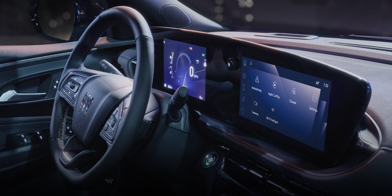 The Interior of a Buick Vehicle at Night with a Large Digital Dashboard Screen Displaying Vehicle Information and Settings