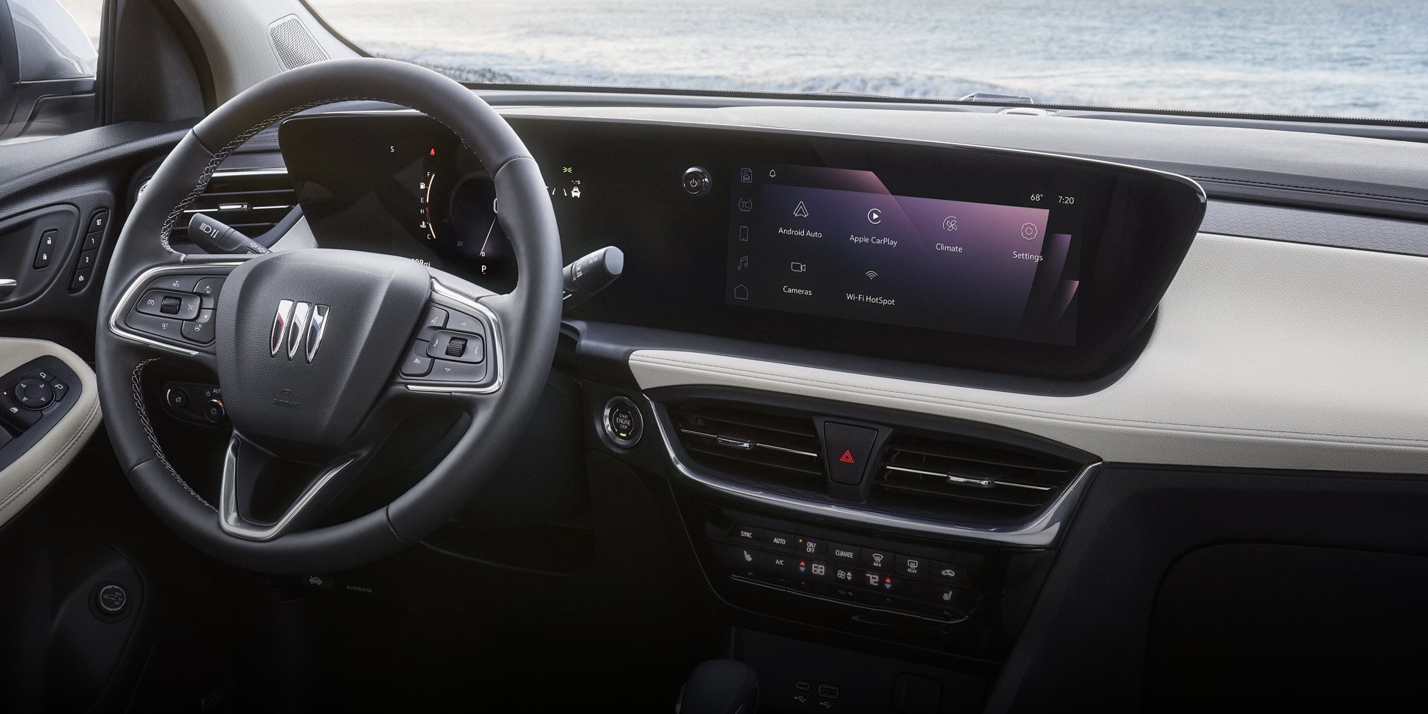  The Interior of a Buick Encore GX with a View of the Ocean from the Windshield and an Infotainment Screen Displaying Apps