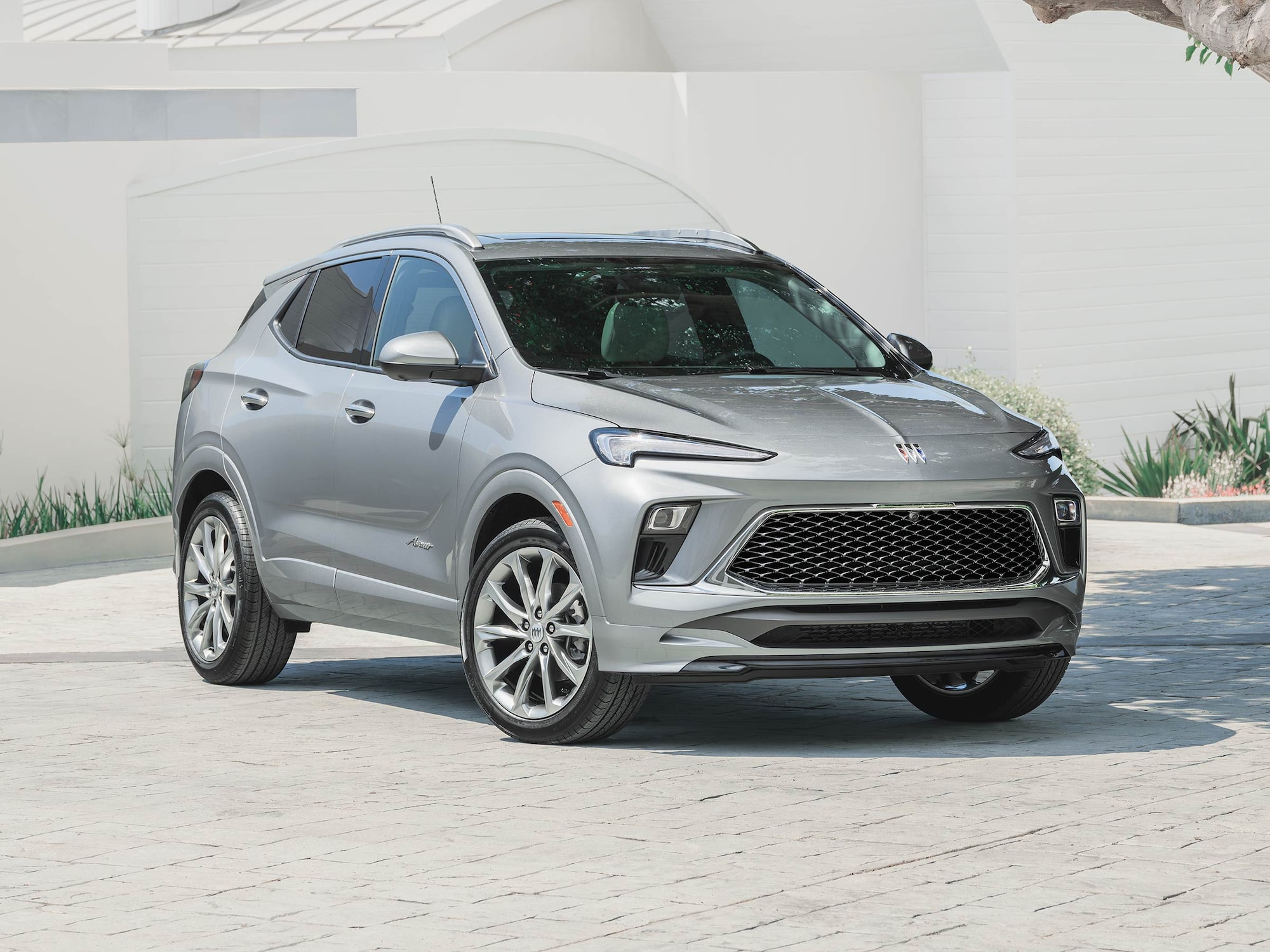 A Gray Buick SUV Parked in front of a Modern White Building with Green Landscaping