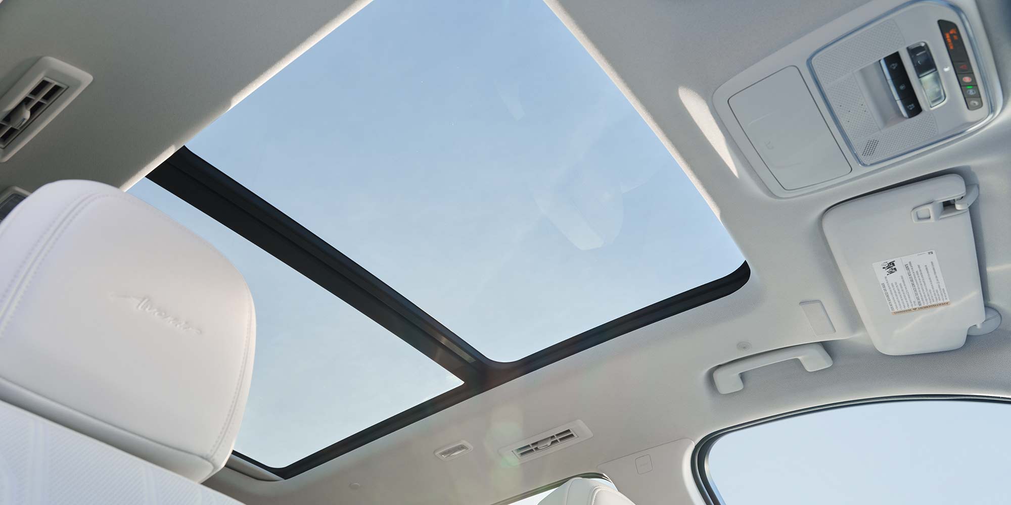 The Interior of a Buick Avenir with a Panoramic Sunroof and White Seats