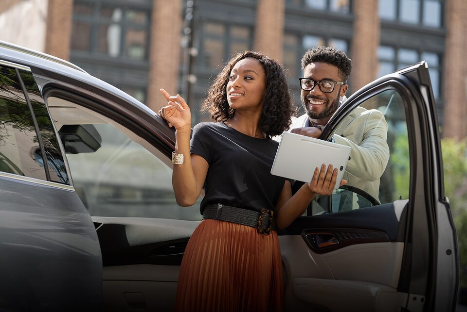 A Women Smiling Driving her Buick Envision with the Moonroof Open