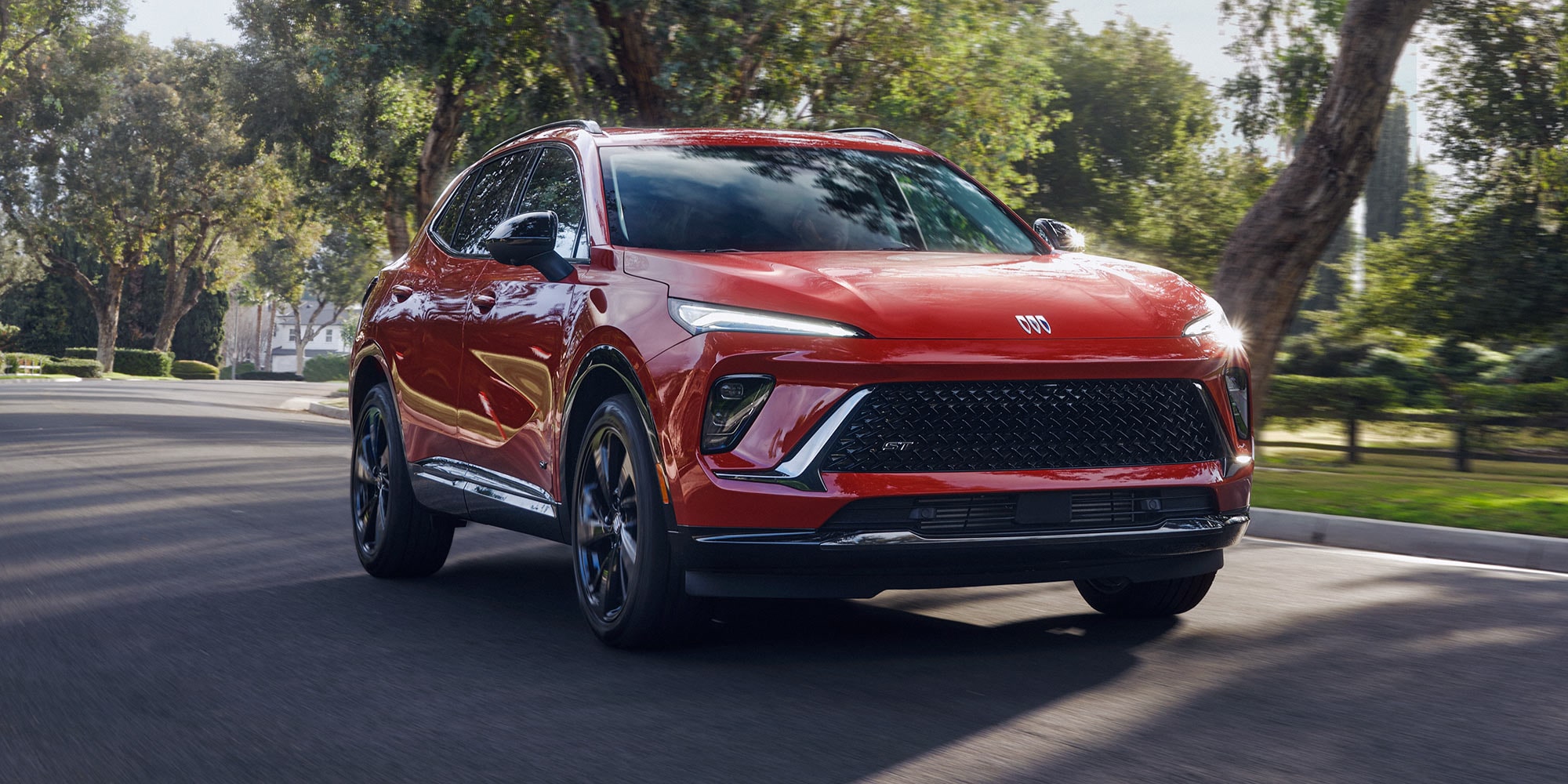 Front View of the Buick Envision Driving Through a Neighborhood