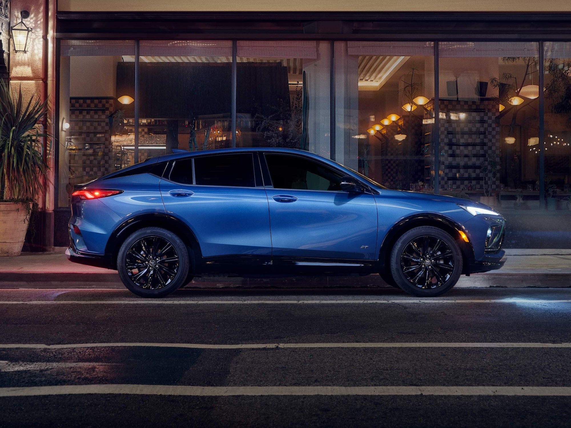 Profile View of the Buick Envista Compact SUV Parked on a City Street at Night