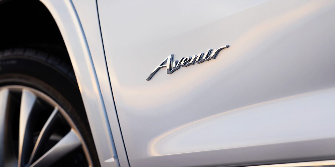 Chrome Avenir Badge on the White Fender of a Buick Vehicle