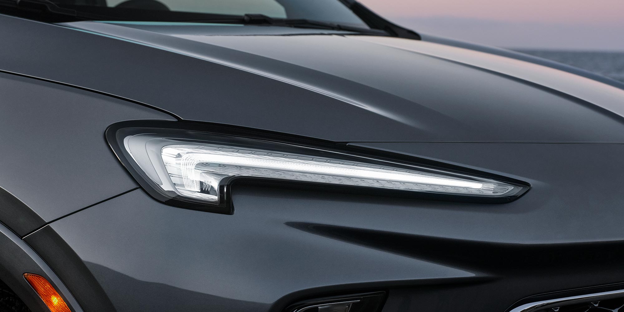A Close-Up of the Sleek Headlight Design on a Dark Gray Buick SUV