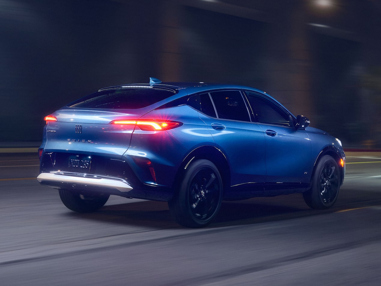 A Blue Buick Envista Compact SUV Driving Away at Night with Its Taillights Illuminated