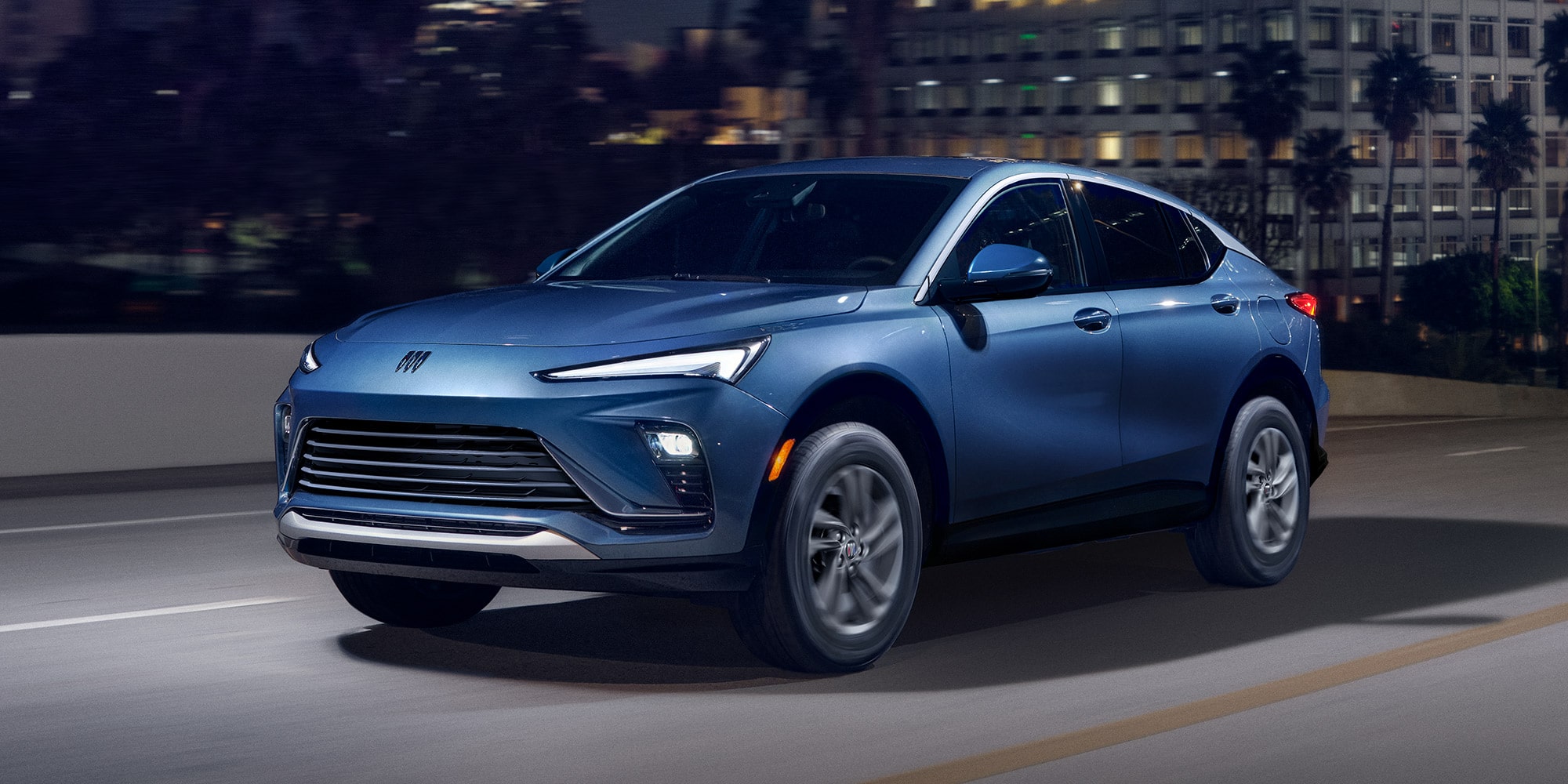 Three-quarters view of the 2026 Buick Envista Driving Out of the City Under a Street Light