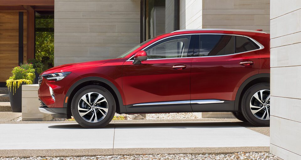 The Cinnabar Metallic Envision Avenir Speeding Through a Freshly Rained Road