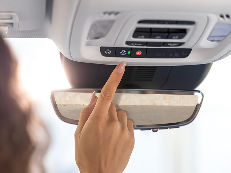 Close-up of a Woman Pressing the OnStar Button in Her Buick Envision