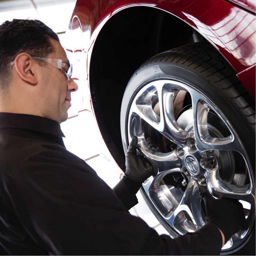 Certified Service Technician Rotates Tire