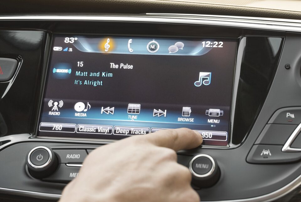 Image of a person using the color touch radio in a Buick vehicle.