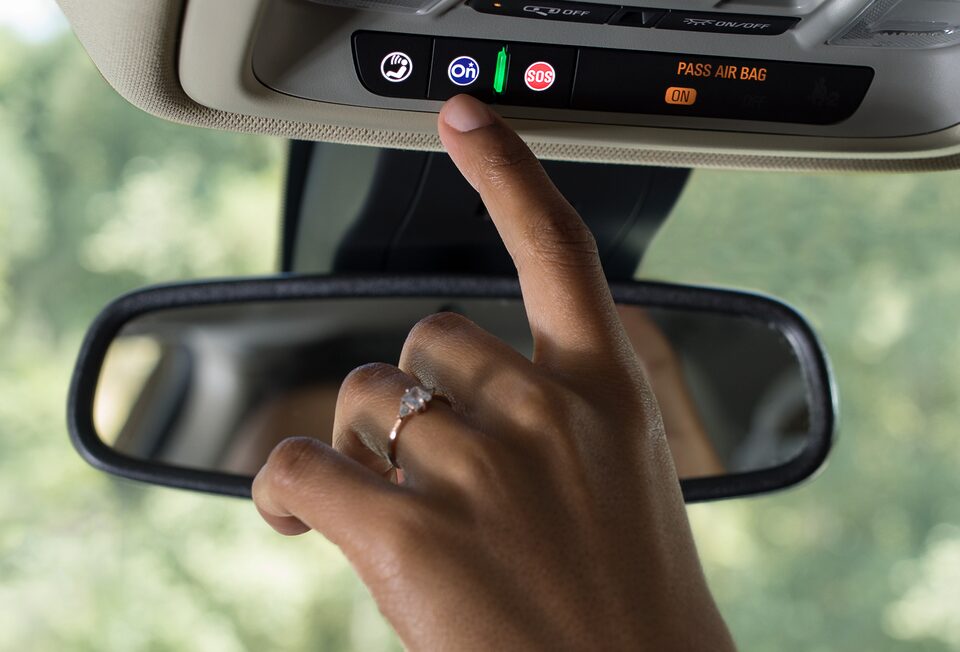 Driver Pressing OnStar Services Button in Buick Vehicle
