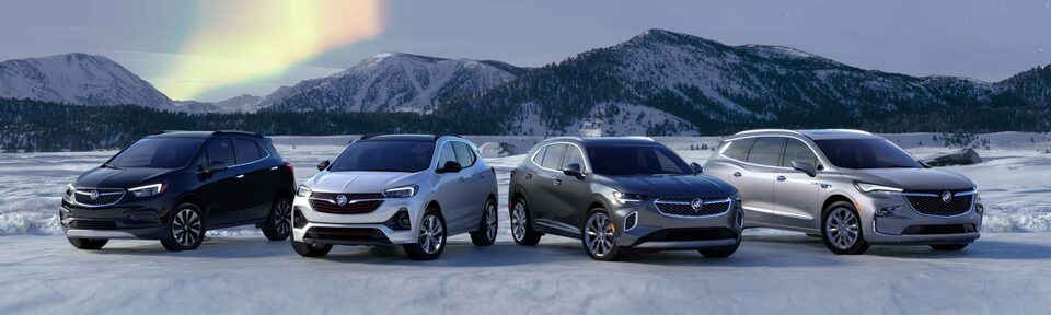 The Buick Vehcile Lineup Parked on Snow with Mountains and a Aurora in Background