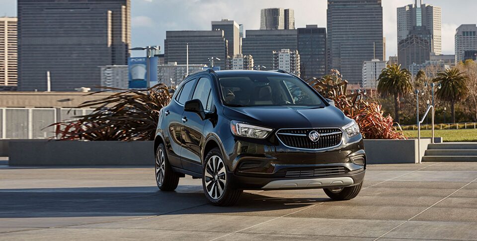 The Buick Encore Parked on a Frozen Lake with a Mountain Backdrop Under the Breathtaking Northern Lights
