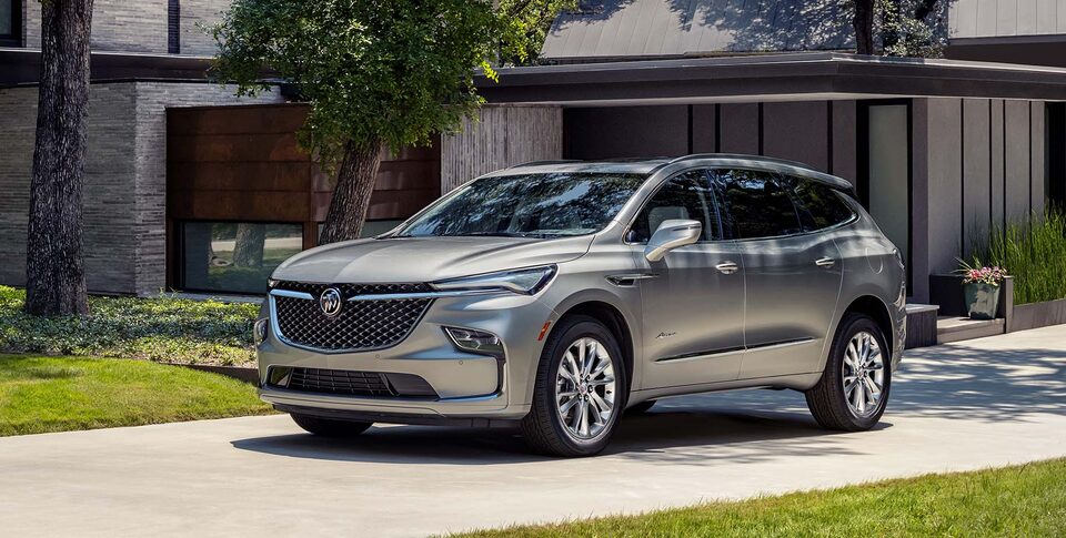 The Buick Enclave Parked In the Street next to a House
