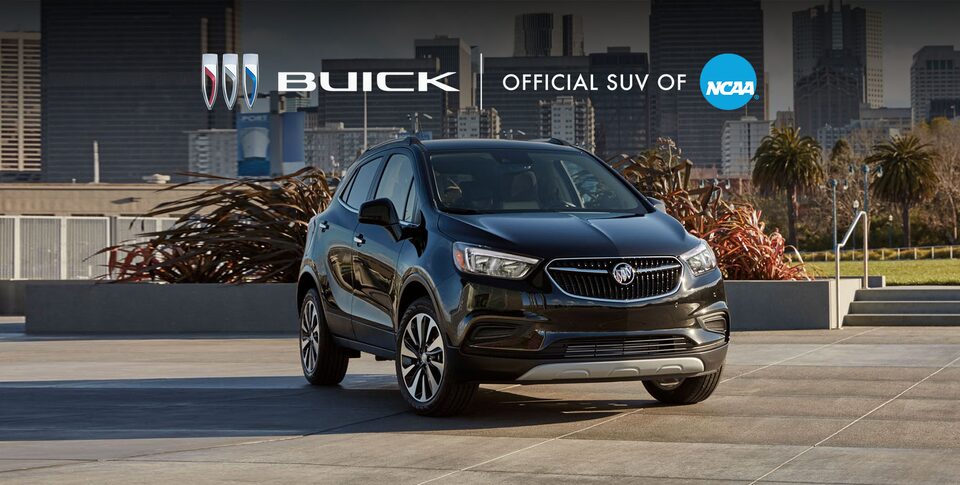 The Buick Encore Parked on a Frozen Lake with a Mountain Backdrop Under the Breathtaking Northern Lights