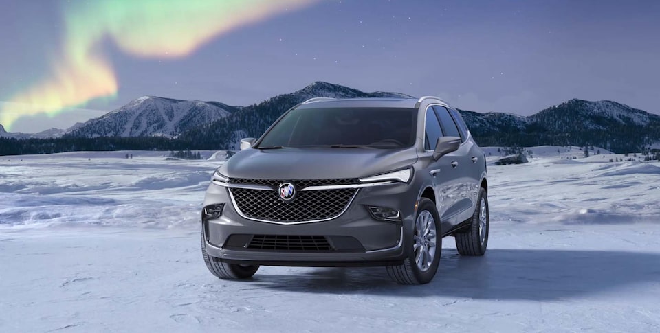 A Closeup of the Enclave Avenir Parked on a Frozen Lake with a Mountain Backdrop