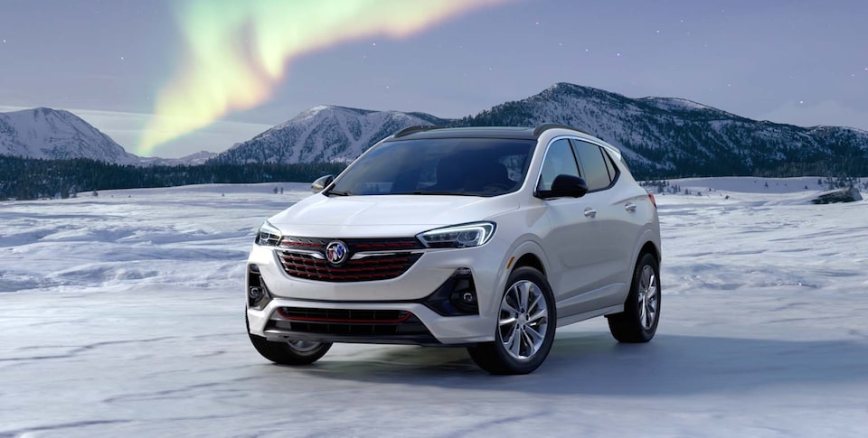 Closeup of The Buick Encore GX Parked on Snow with a Mountain Backdrop Under the Northern Lights
