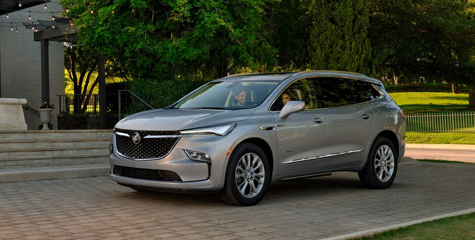 The Buick Enclave Parked In the Street next to a House