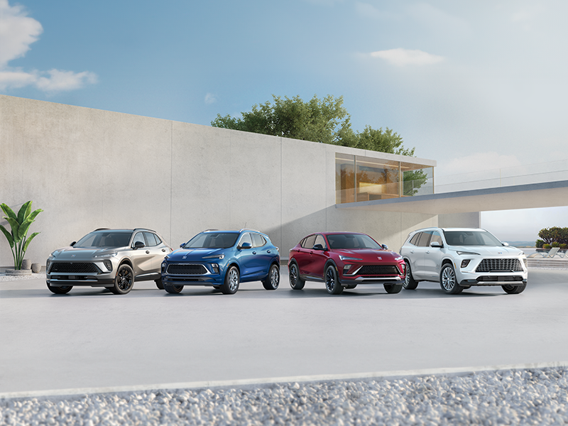 A Buick SUV Lineup Featuring a Gray Buick Envision, Blue Buick Encore GX, Red Buick Envista, and White Buick Enclave Parked in Front of a Modern Luxury Home Exterior