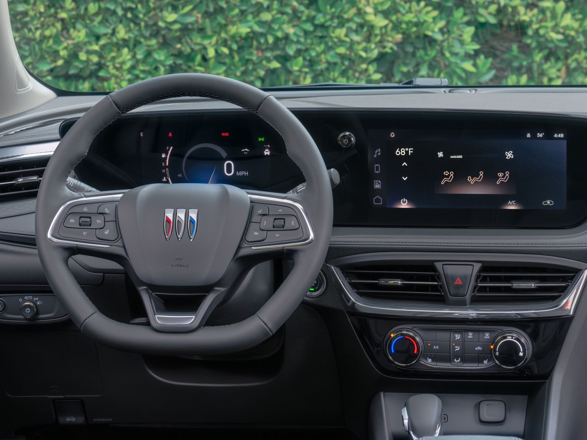 The Interior Dashboard of a Buick Vehicle Featuring Its Steering Wheel and Climate Controls