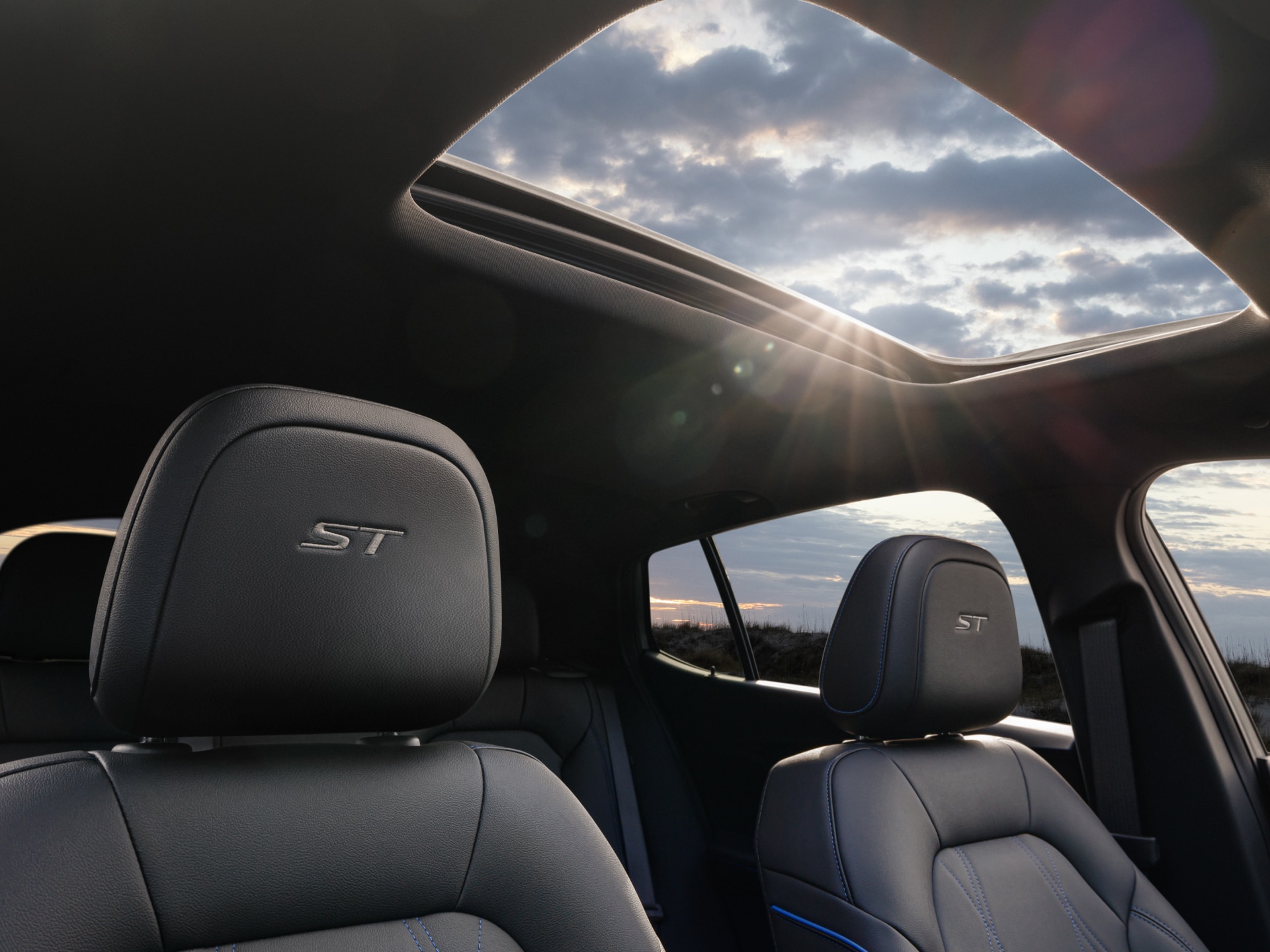 The Interior of a Buick Vehicle Showing Headrests With ST Logos and a Panoramic Sunroof