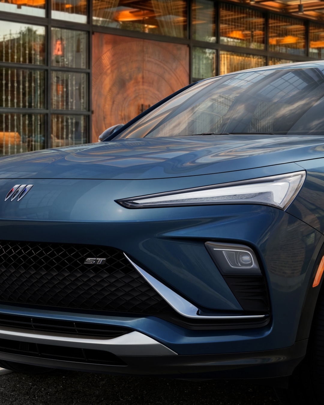 A Close-Up of the Front Right Quarter of a Blue Buick Envista SUV Highlighting the Headlight and Grille with an ST Badge