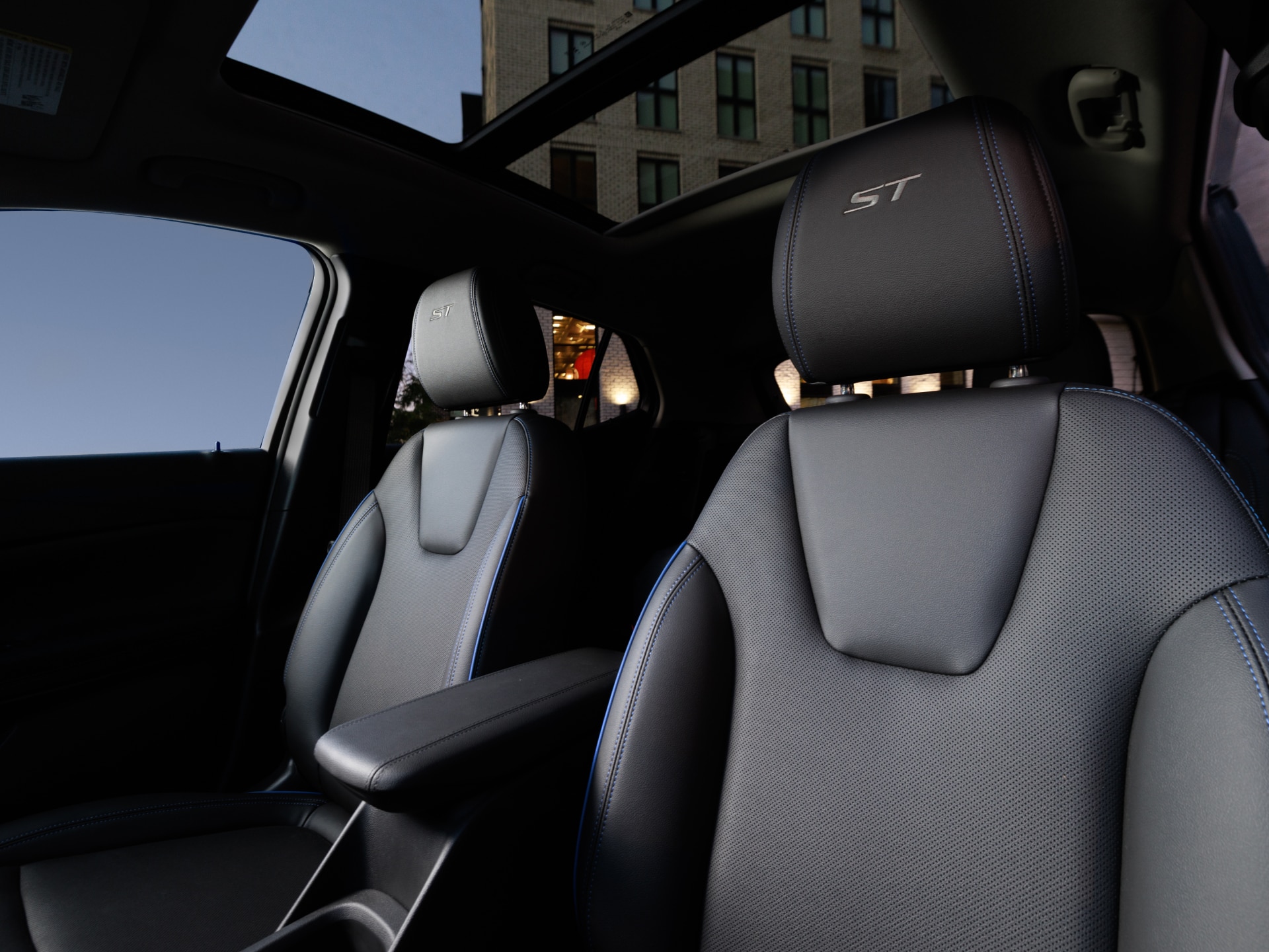 An Interior View of a Buick Vehicle Showing Black Leather Seats with Blue Stitching and ST Embroidery and a Panoramic Sunroof