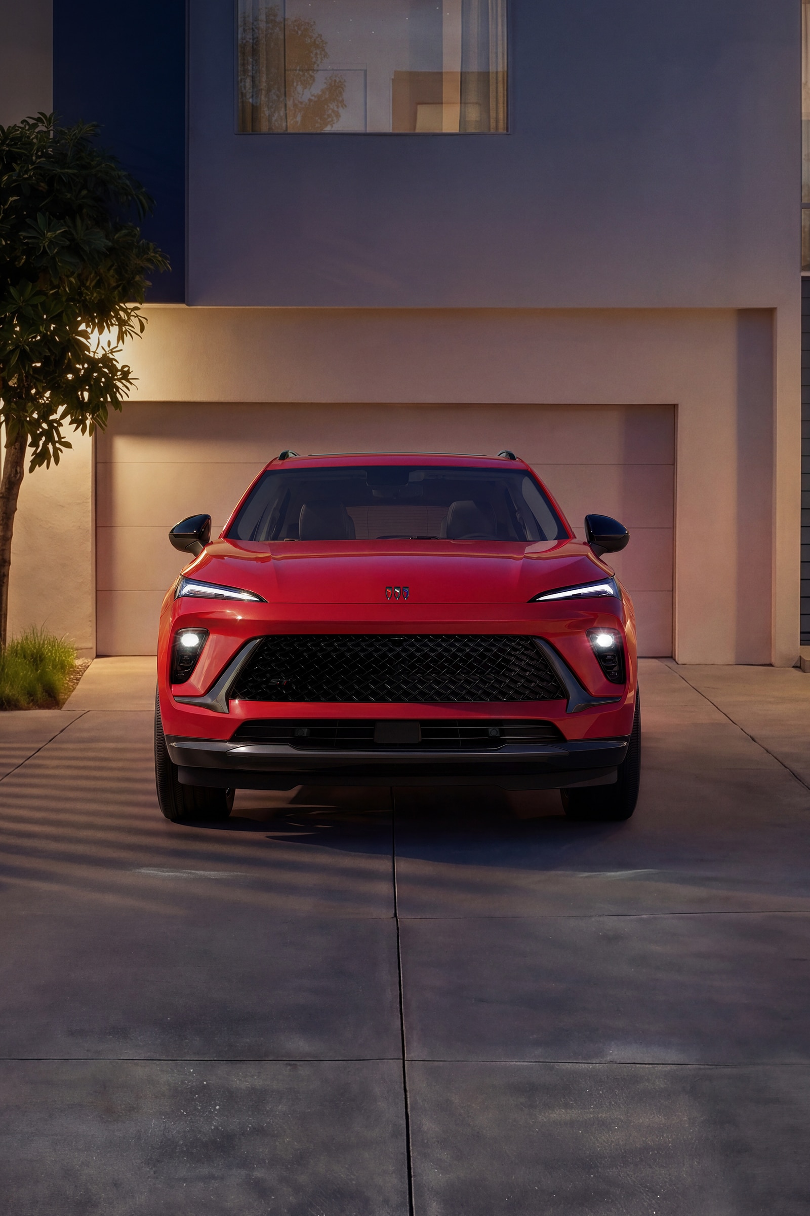 A Red Buick Envision SUV Parked in a Driveway at Night