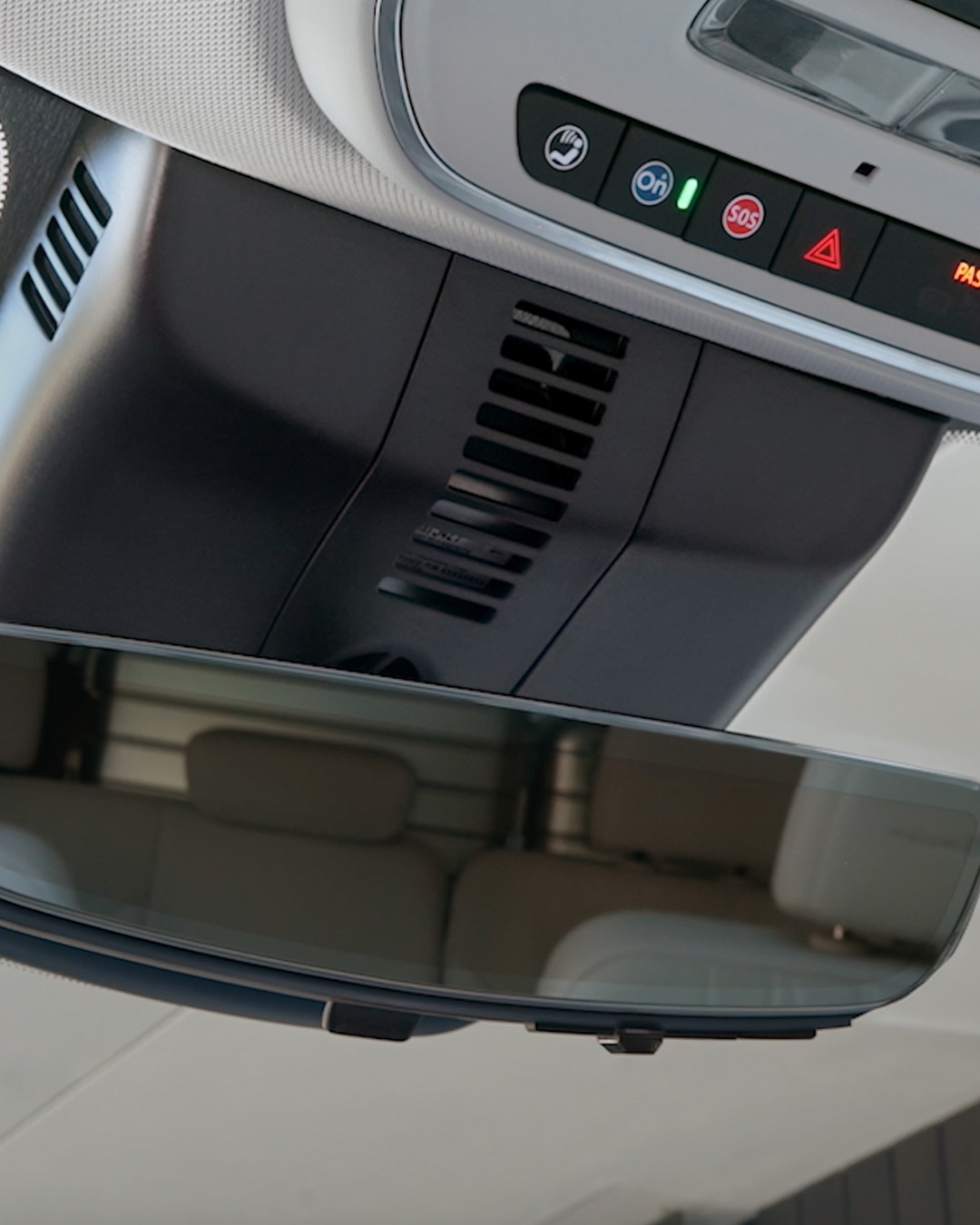Close-up View of a Buick Vehicle's Rearview Mirror and Overhead Console Reflecting Building Architecture