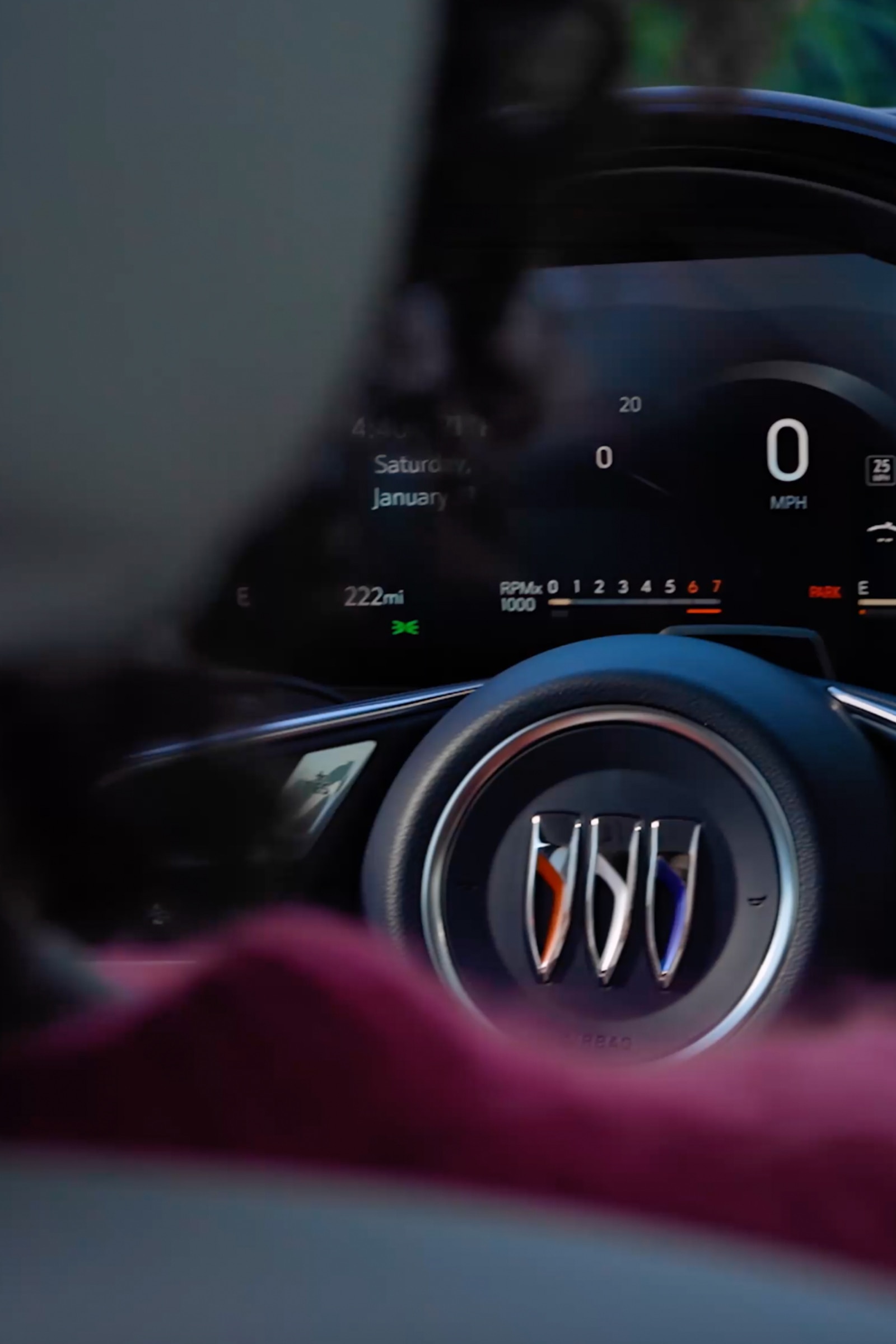 A Close-Up View of a Buick Steering Wheel With the Buick Logo And a Digital Dashboard