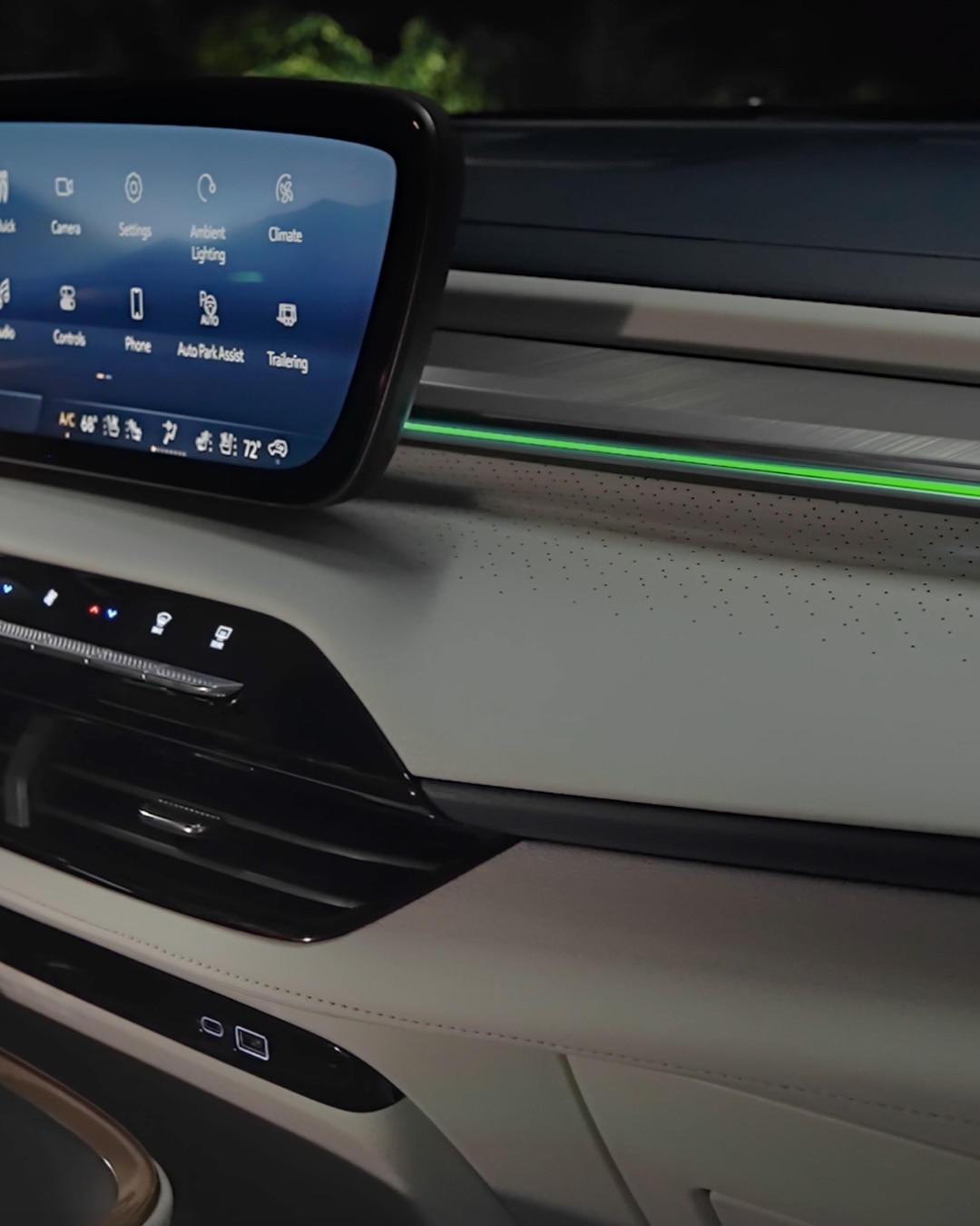 Close-up of the Interior Dashboard of a Buick Vehicle At Night with an Infotainment Screen and Green Ambient Lighting