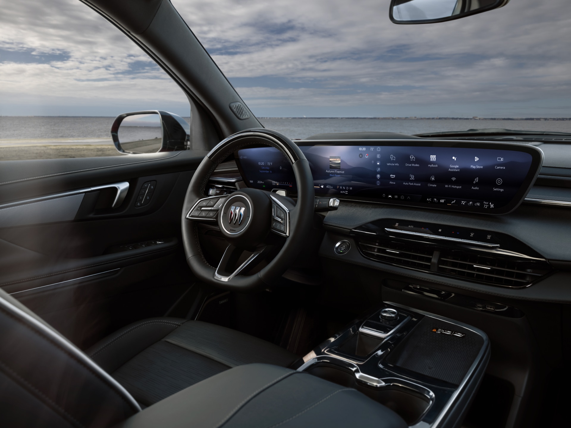 The Interior View of a Buick Car with a Steering Wheel and a Wide Digital Dashboard Near a Beach